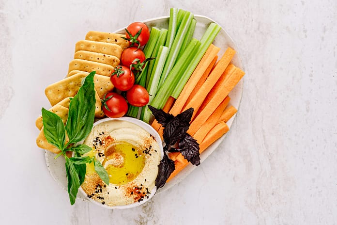 Homemade Hummus Recipe - Aldona's Kitchen Top view of a delicious vegetable platter with hummus, ideal for healthy snacking.